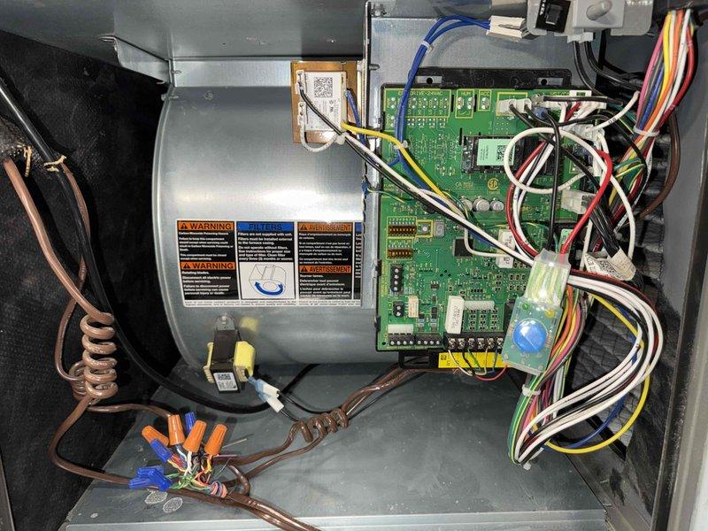 Completed annual air conditioning maintenance and tune-up on a 4-year-old residential cooling system. Performed comprehensive inspection of all major components including blower motor assembly, refrigerant lines, and electrical connections. Examined control board circuitry and verified proper operation of outdoor discharge air sensor and integrated circuit components. Checked wire terminations and connections throughout the system, ensuring all wire nuts and harness connections were secure. Inspected copper refrigerant lines for proper insulation and connections to blower motor housing. Verified all safety labels and operational information were visible and legible. System tested and operating within normal parameters upon completion of maintenance service.