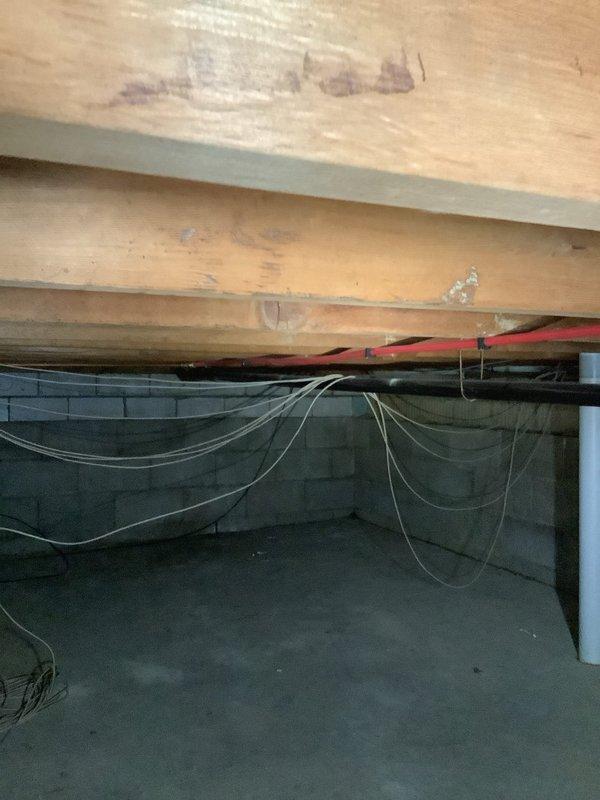 Responded to kitchen sink backup at 65-year-old residence. Upon arrival, water was draining slowly but not actively backing up. Inspected crawl space and identified improper plumbing installation by previous homeowner, including a hard 90-degree angle in drain line that was contributing to drainage issues. Assessed corroded plumbing fixtures showing significant copper oxidation and verdigris buildup at floor connections, indicating long-term water exposure and deterioration. Documented existing conditions including compromised pipe fittings, mineral deposits, and debris accumulation around affected areas. Provided customer with findings regarding substandard pipe configuration in crawl space and recommended future repairs to address both the improper drain angle and corroded fixture components to prevent recurring drainage problems.