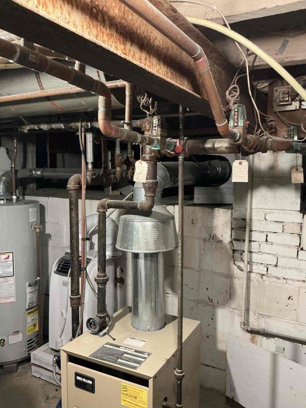 Completed estimate for high-efficiency boiler replacement to eliminate chimney venting requirements. Assessed existing Weil-McLain boiler system with associated piping network showing significant corrosion on horizontal supply lines, evaluated mechanical room layout including water heater and existing infrastructure, and documented current installation conditions. Provided recommendations for new high-efficiency condensing boiler system with PVC venting to address customer's need to move away from chimney dependency.