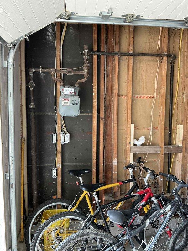 Conducted comprehensive electrical assessment for generator installation at residential property. Evaluated existing electrical panel configuration, verified available breaker capacity, and documented current electrical infrastructure including conduit routing and connection points in garage area. Photographed panel layout showing multiple circuit breakers and assessed structural considerations for generator tie-in to existing system.
