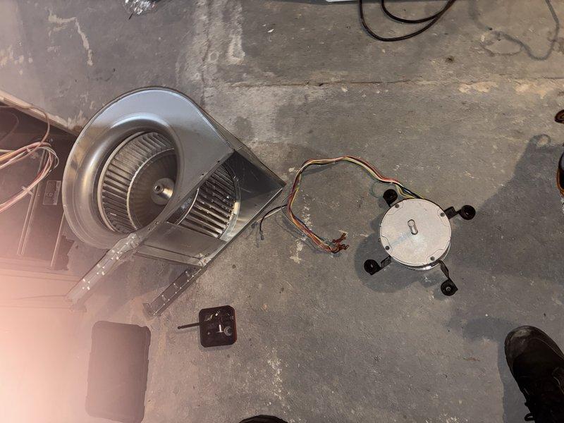 Diagnosed blower motor failure with voltage present at motor terminals, indicating motor burnout and potential control board malfunction. Replaced defective blower motor assembly and circuit board to restore proper system operation. Removed old dual squirrel cage blower wheel assembly from housing, disconnected failed motor with capacitor, and installed new motor and control board with proper wiring connections. Tested system operation and verified airflow restoration upon completion.