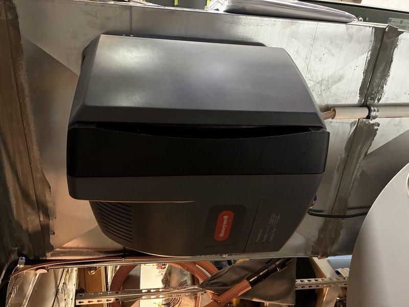 Completed air conditioning tune-up and seasonal maintenance inspection. Documented existing humidifier evaporator pad showing significant mineral buildup and scaling, indicating need for replacement to maintain proper humidity control and system efficiency. Provided complimentary carbon monoxide detector installation for enhanced safety.