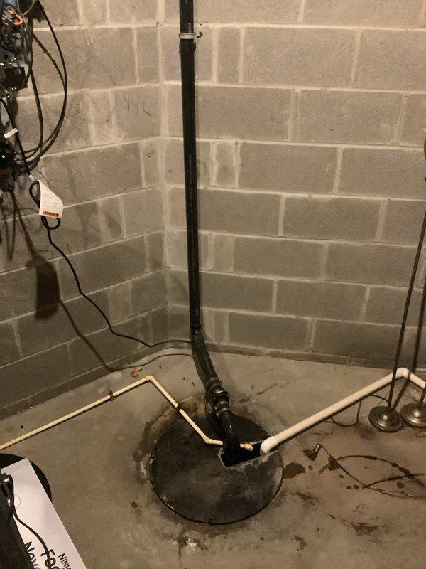 Responded to sump pump overflow and drainage blockage in 20-year-old residential property. Upon inspection, identified compromised sump pump system in basement with discharge pipe configuration issues and evidence of water intrusion around basin perimeter. Assessed exterior drainage concerns including significant standing water accumulation on patio area, indicating potential backflow or inadequate discharge routing. Cleared blockage from pump system, verified proper operation of discharge lines, and restored functionality to prevent further basement flooding and exterior water pooling.