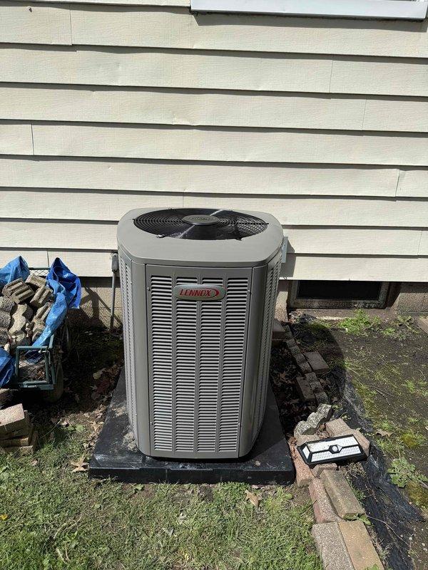 Completed installation of a new Lennox 90% AFUE gas furnace and matching air conditioning system. Unit was positioned on a composite pad against the building exterior with proper clearances maintained. System was evacuated to 265 microns as verified with calibrated vacuum gauge, charged to manufacturer specifications, and tested for proper operation of all heating and cooling functions.