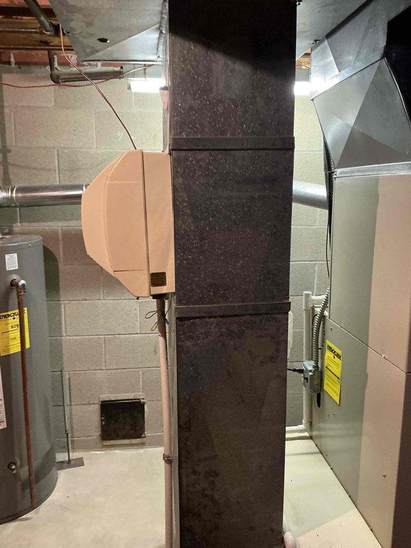 Conducted on-site evaluation for complete HVAC system replacement of 22-year-old furnace and air conditioning unit. Assessed existing equipment in basement mechanical room, including aging ductwork system with visible weathering and dust accumulation on vertical rectangular trunk line. Documented current furnace installation with beige metal cabinet, existing electrical conduit connections, PVC condensate drainage system, and associated ductwork configuration. Evaluated system accessibility, existing infrastructure compatibility, and mechanical room layout for replacement equipment installation. Provided comprehensive estimate for new furnace and air conditioning system under promotional offer.