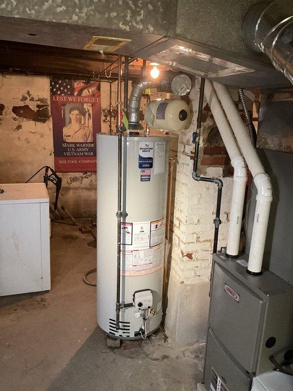 Replaced a leaking 2010 Bradford White 40-gallon tall water heater with a new Bradford White 40-gallon tall unit featuring a 6-year manufacturer warranty. Rebuilt hot and cold water supply lines, installed a new cold water shut-off valve, and added a thermal expansion tank to meet current code requirements. Due to basement access constraints, utilized a two-technician team to safely remove the failed unit and install the replacement equipment.