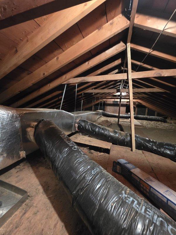 Completed annual air conditioning maintenance on 1-year-old Lennox cooling system. Performed comprehensive system inspection including outdoor condenser unit evaluation, refrigerant level verification, electrical connection testing, and component cleaning. Accessed upper level crawl space to inspect and service air filters, examined ductwork system throughout attic space including black flexible duct runs for proper airflow and connections. Provided thermostat operation instruction to restore system functionality. All components found operating within normal parameters with no deficiencies noted.