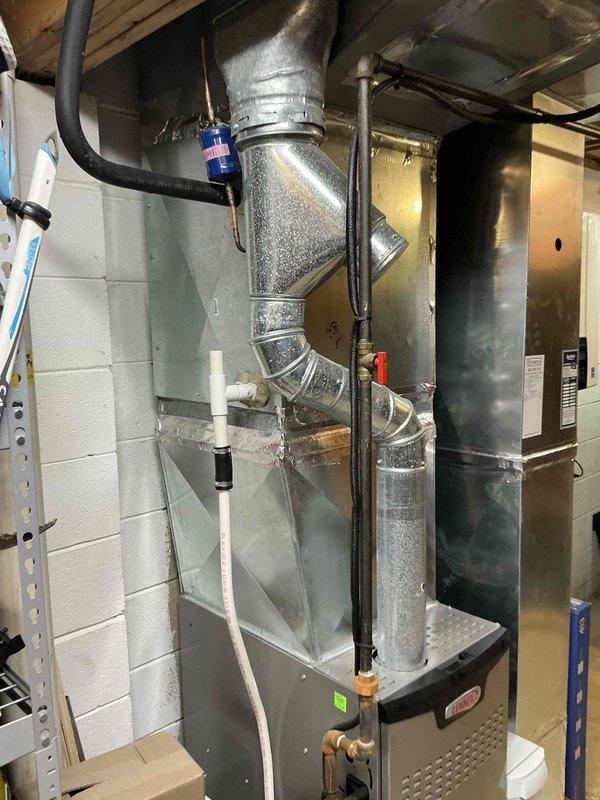 Completed HVAC estimate for air conditioning replacement due to identified leak in existing system. Evaluated residential basement installation featuring Lennox furnace with associated ductwork, exhaust piping, and auxiliary components. Documented current equipment configuration including gray metal cabinet furnace unit, metallic ductwork network with Y-junction connections, PVC drainage piping, and flexible tubing. Assessed system layout and mechanical room conditions to provide replacement recommendations and confirm ductwork compatibility for new equipment installation.