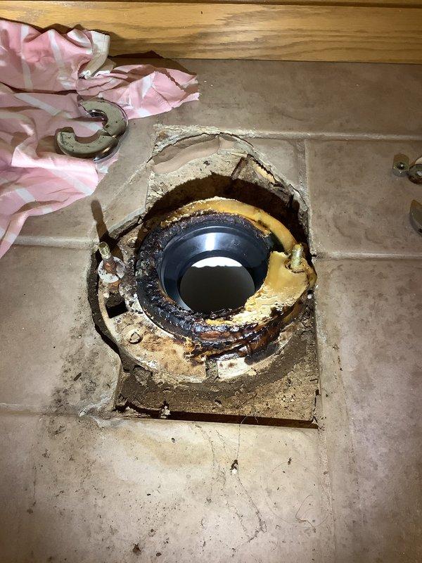 Completed full toilet rebuild including replacement of flush valve, fill valve, and tank-to-bowl hardware. Removed and reset toilet with new wax ring, closet bolts, and shut-off valve. Addressed corroded and deteriorated toilet flange showing significant rust, oxidation, and old wax ring buildup on tile floor installation.