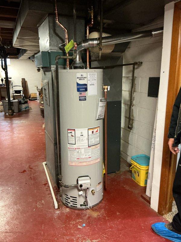 Replaced 40-gallon tall water heater in basement with new Bradford White unit. Installed new expansion tank, ball valve, and hard-piped flue connection to existing chimney liner. All copper supply lines were connected with appropriate brass fittings and valves, ensuring proper water flow and safety compliance. The installation included complete integration with existing plumbing infrastructure and proper venting through the chimney penetration.