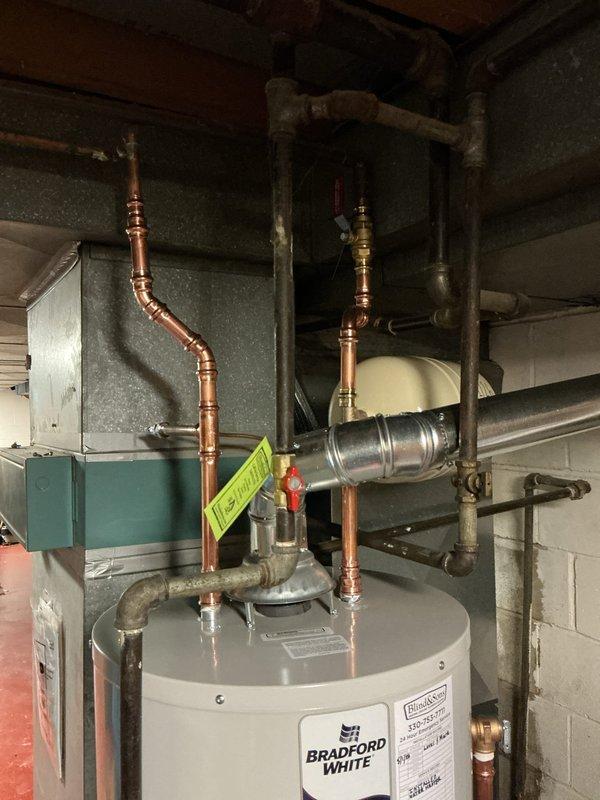 Replaced 40-gallon tall water heater in basement with new Bradford White unit. Installed new expansion tank, ball valve, and hard-piped flue connection to existing chimney liner. All copper supply lines were connected with appropriate brass fittings and valves, ensuring proper water flow and safety compliance. The installation included complete integration with existing plumbing infrastructure and proper venting through the chimney penetration.