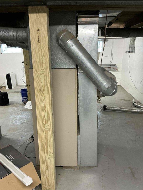 Completed HVAC estimate for heat pump and propane furnace replacement in new rehabilitation property. Assessed existing basement mechanical space with concrete block walls, exposed ceiling joists, and current ductwork configuration including galvanized metal supply ducts and air handler unit. Documented installation area conditions, support structures, and spatial requirements for proposed equipment replacement system.