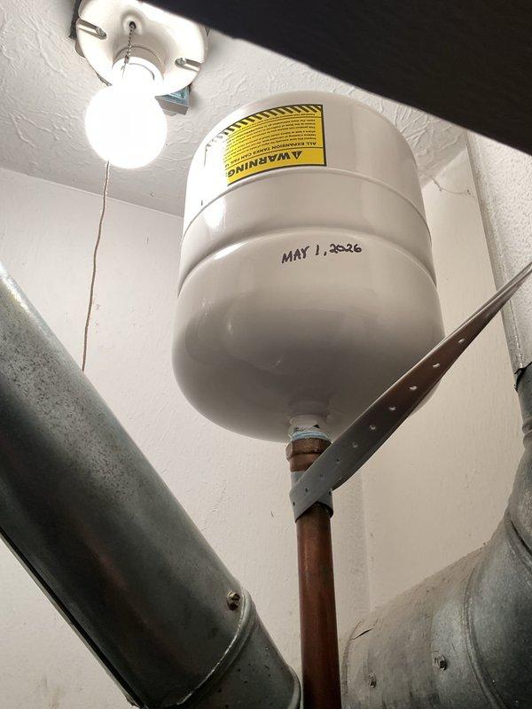 Responded to service call for tanked water heater producing rumbling noises. Upon inspection, identified an AO Smith residential water heater exhibiting symptoms consistent with sediment accumulation at the tank bottom. Performed complete tank flush procedure by connecting garden hose to drain valve, draining contents until water ran clear, and removing mineral deposits and sediment buildup that had caused the reported rumbling sounds. Inspected all visible plumbing connections, copper supply lines, and pressure relief valve for proper operation and signs of corrosion or leakage. Verified temperature and pressure settings were within manufacturer specifications and confirmed unit returned to normal, quiet operation following the flush procedure.