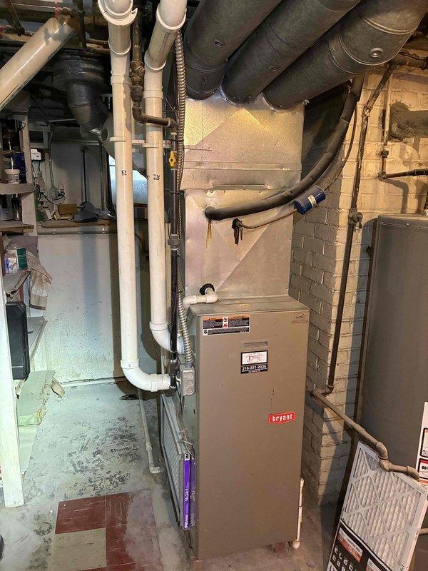 Completed routine air conditioning maintenance on 17-year-old residential cooling system. Performed inspection of outdoor condenser unit, which showed significant dirt and debris accumulation on coil surfaces requiring attention. Inspected indoor Bryant furnace and associated ductwork in basement mechanical room, verified system operation, and confirmed proper airflow through the HVAC system.