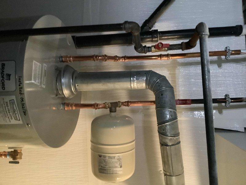 Replaced existing 40-gallon short atmospheric vent natural gas water heater in basement. Installed new ball valve, gas cock, and expansion tank to bring system up to current code requirements. Existing flue pipe was inspected and determined to be in good condition, requiring no replacement. All copper supply lines were reconnected with proper compression fittings, and the unit was tested for proper operation and safety compliance.