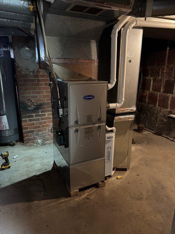 Completed installation of add-on air conditioning system with new evaporator coil to existing Carrier furnace in basement utility area. Installed new A/C coil unit with proper ductwork connections, mounted air handler securely to ceiling joists, and integrated refrigerant lines with existing HVAC infrastructure. System tested and verified operational with all components functioning within manufacturer specifications.