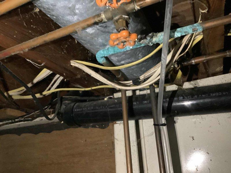 Responded to slow-draining vanity sink in bathroom of 50-year-old home. Upon inspection, accessed plumbing system through crawl space and identified drainage issue related to aged piping infrastructure. Examined supply line connections, shut-off valves, and drain assembly showing mineral buildup and corrosion consistent with original plumbing installation. Cleared obstruction from drain line, verified proper water flow, and tested system to ensure complete drainage restoration. All fixtures returned to normal operation.