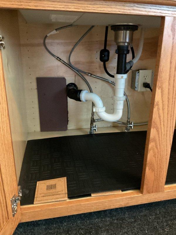Removed existing stainless steel kitchen sink and installed customer-supplied undermount stainless steel sink with protective grid rack into granite countertop. Installed new black matte finish pull-down kitchen faucet with spray head. Connected all plumbing components including P-trap assembly to existing garbage disposal unit, verified proper drainage, and tested all connections for leaks.