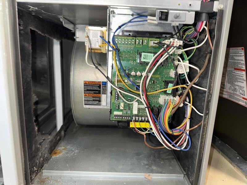 Performed routine maintenance inspection on 14-year-old air conditioning system. Accessed interior components and control board to verify electrical connections and system operations. Identified moderate dust and debris accumulation on blower wheel fins and internal components. Inspected control board wiring, blower assembly, and cabinet interior, noting all connections secure and circuit board functioning properly despite age of unit. System operational at time of service completion.