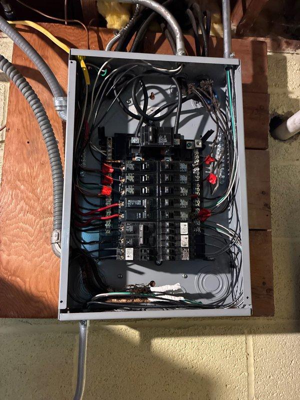 Completed AC circuit installation and panel wiring improvements in residential basement electrical system. Organized and terminated multiple branch circuits within the main load center, installing circuit breakers and establishing proper wire management throughout the panel enclosure. Routed metallic conduit from panel to service areas, ensuring code-compliant protection for electrical conductors in the unfinished basement space.