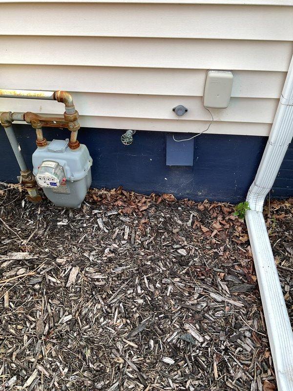 Responded to service call for non-functioning outdoor spigots and leaking garbage disposal. Inspected front and rear exterior hose bibs, confirming rear spigot supply line was disconnected during previous bathroom remodel and front spigot required repair due to failed internal components. Evaluated InSinkErator garbage disposal unit and identified active leak at mounting flange or drain connection. Documented existing conditions with photographs of disposal unit from above showing wear patterns and exterior utility area near foundation. Provided assessment of required repairs including potential supply line restoration for rear spigot, component replacement or installation for front spigot, and disposal leak remediation through gasket replacement or unit resealing.