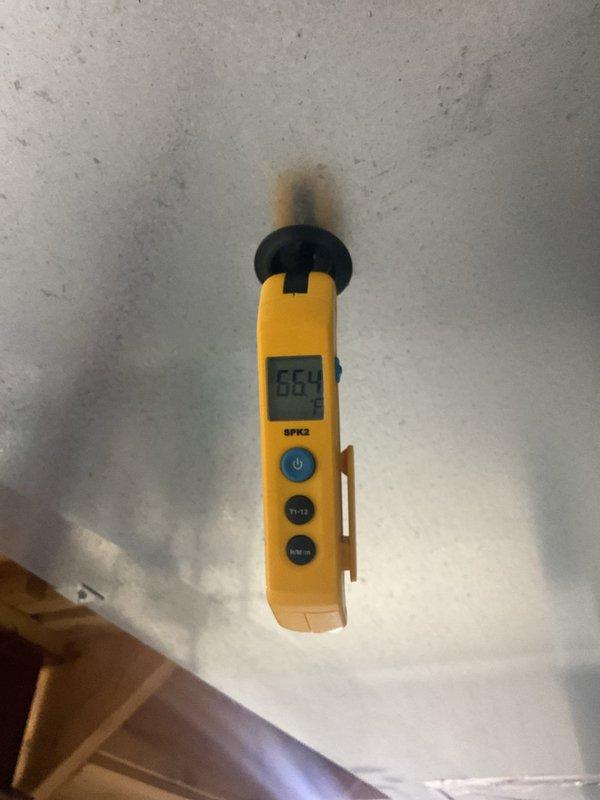 Performed routine HVAC maintenance on residential cooling system. Inspected outdoor condensing unit, verified proper installation on pad with adequate clearance, checked refrigerant line connections and electrical disconnect. Measured and recorded system parameters including temperature readings of 66.1°F to assess operational performance and ensure unit is functioning within manufacturer specifications.