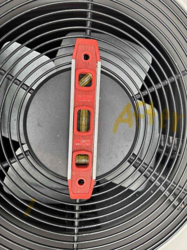 Responded to service call for excessive noise from outdoor Lennox air conditioning condenser unit. Upon inspection, confirmed unit was improperly installed on unlevel concrete pad, causing increasing vibration and noise when fan motor operates. Verified unit is out of level using torpedo level on top grille assembly. Improper ground preparation beneath pad is causing instability and operational issues requiring correction.