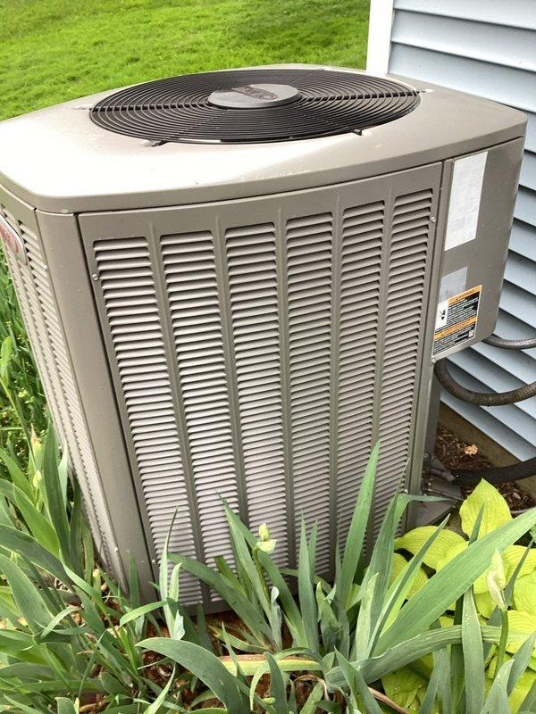 Completed routine MVP cooling maintenance visit on residential HVAC system. Inspected indoor air handler and documented air filter condition showing moderate dust accumulation on mesh filter media within black plastic frame. Evaluated outdoor condensing unit positioned on exterior pad, confirming proper clearance from landscaping and noting operational status of fan assembly and louvered cabinet panels. System components appeared functional with standard seasonal wear patterns observed on outdoor equipment.