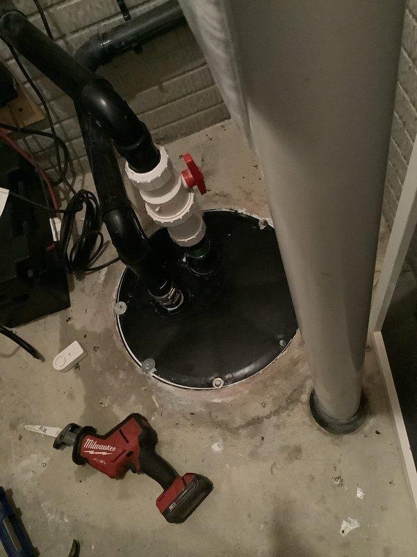 Responded to a floor drain obstruction caused by a golf ball that entered a 2" floor drain connected to a grinder pump crock. Attempted multiple methods to clear the obstruction, including running water from the water heater through the floor drain to flush the golf ball into the crock, but was unsuccessful in dislodging it. Used solder wire to probe the drain trap for obstructions with no detectable blockage found in the trap itself. Due to the small diameter of the drain line, camera inspection and mechanical snaking were not viable options for retrieval. Inspected the grinder pump basin and found standing water with visible moisture throughout. Assessment indicates the golf ball likely passed through the trap and entered the pump crock where it may be buried beneath accumulated toilet paper and debris. Recommended pumping and cleaning out the grinder pit to locate and remove the golf ball and prevent potential damage to the grinder pump impeller.