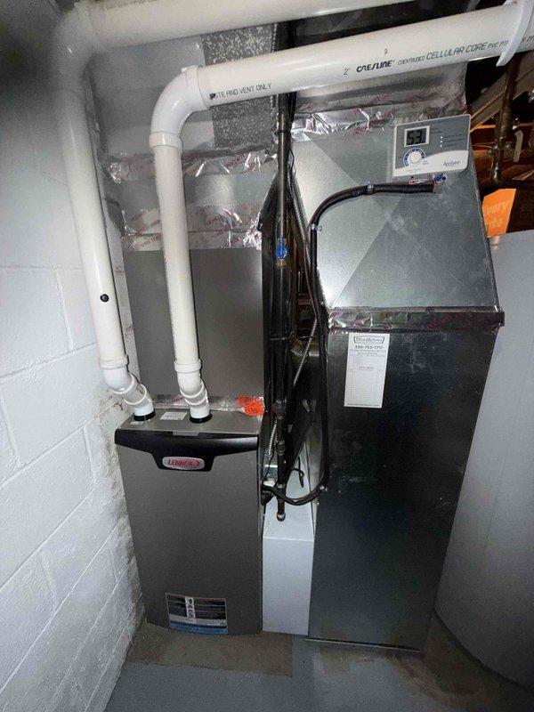 Completed preventative maintenance cooling visit on 6-year-old Lennox air conditioning system. Performed comprehensive inspection of air handler and furnace assembly located in basement utility area. Verified proper operation of electronic control board and blower motor components. Inspected PVC condensate drain lines and confirmed proper drainage configuration with no blockages present. Checked electrical connections, wiring harnesses, and digital display panel functionality. Examined ductwork insulation and verified secure metallic tape sealing. System operating within normal parameters with all safety controls functioning properly.