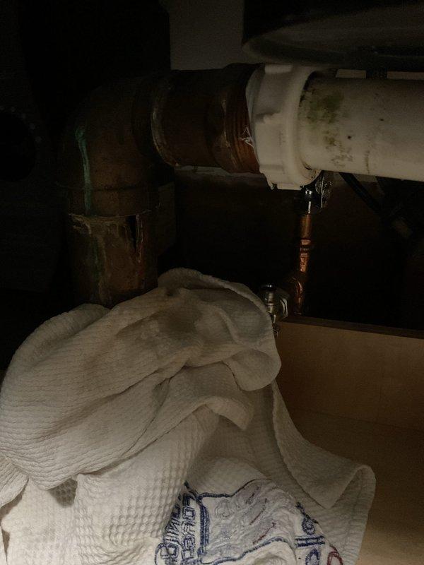 Responded to emergency call for hole in pipe under kitchen sink causing water to gush out during use, threatening newly installed flooring. Accessed plumbing assembly beneath sink and identified compromised section of pipe requiring immediate replacement to prevent further water damage. Replaced damaged pipe section with appropriate materials and secured all connections to restore proper water flow and eliminate leakage. Inspected separate hot water spigot under sink used for beverages and found loose housing requiring attention. Tightened mounting hardware and assessed spigot assembly for structural integrity. Tested all plumbing connections under pressure to verify leak-free operation and proper function of both main supply lines and beverage spigot. Cleaned work area and confirmed no water damage to surrounding cabinetry or newly installed flooring.