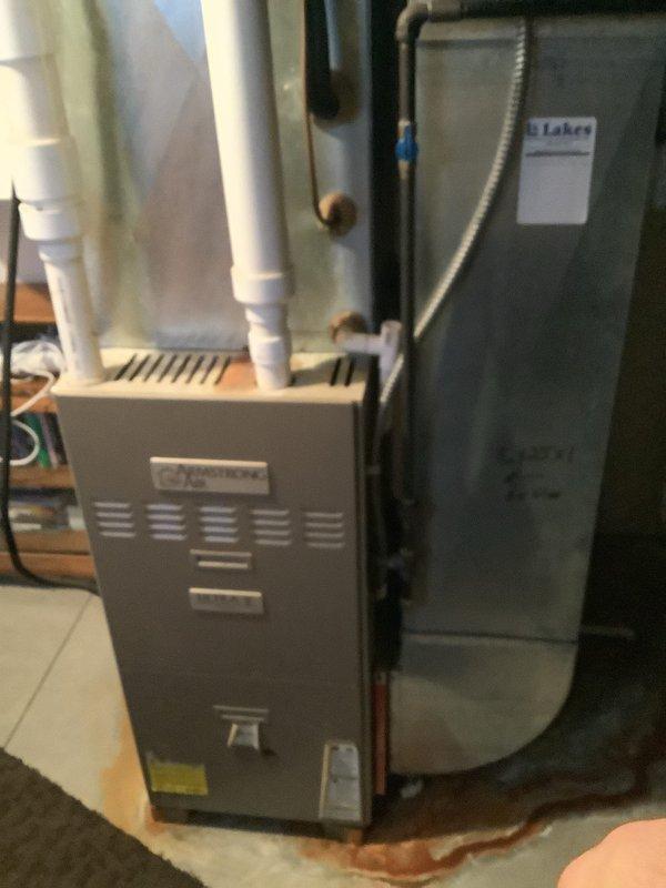 Completed full HVAC system installation including 90% AFUE gas furnace and matching air conditioning condenser unit. Installed indoor furnace unit with proper venting using white PVC piping, connected refrigerant lines with service valves, and positioned outdoor AC condenser on concrete pad against exterior wall. Ran electrical conduit and wiring to outdoor unit, secured all copper line sets, and verified all mechanical connections for proper system operation.