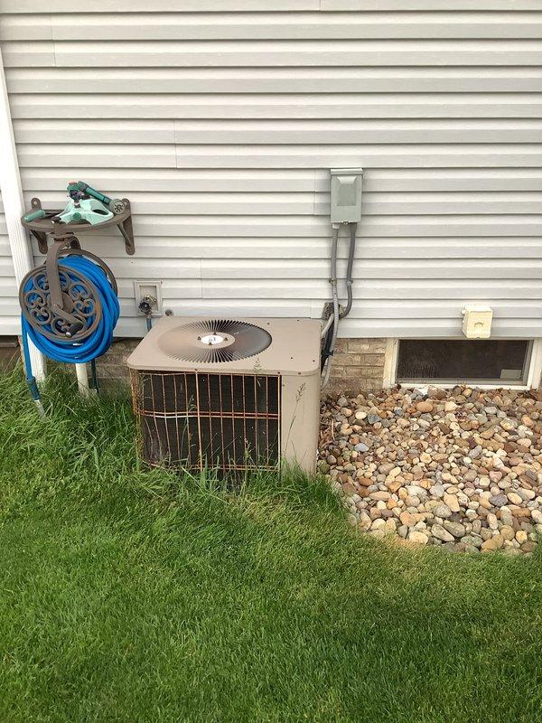 Completed full HVAC system installation including 90% AFUE gas furnace and matching air conditioning condenser unit. Installed indoor furnace unit with proper venting using white PVC piping, connected refrigerant lines with service valves, and positioned outdoor AC condenser on concrete pad against exterior wall. Ran electrical conduit and wiring to outdoor unit, secured all copper line sets, and verified all mechanical connections for proper system operation.