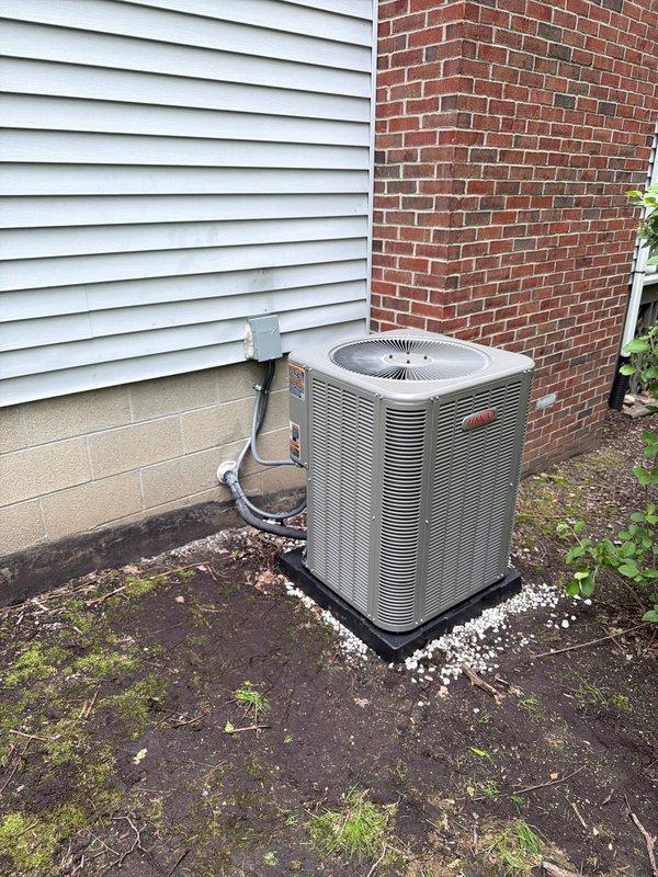 Completed full HVAC system installation including 80% AFUE gas furnace, central air conditioning condenser unit, and hot water heater. Installed new Lennox outdoor condensing unit on equipment pad with proper clearances between building structures. Unit positioned on black composite pad with gravel base for drainage and stability. Ran and insulated refrigerant lines from outdoor unit to indoor air handler, securing lines along exterior wall. Connected electrical service and installed disconnect box at exterior location per code requirements. Replaced 30-amp cartridge fuses in electrical disconnect during installation process. Verified all electrical connections, tested system operation, and confirmed proper refrigerant charge levels. System startup successful with all components functioning within manufacturer specifications.
