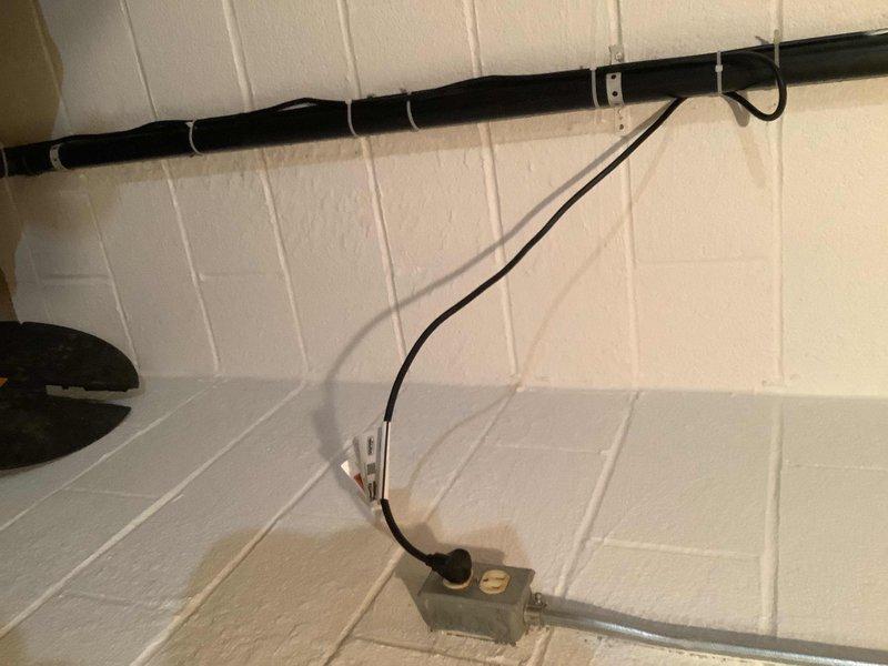 Responded to service call for sump pump failure where unit was not triggering properly. Upon inspection, found submersible pump installed in basement floor basin with standing water present. Evaluated pump operation, electrical connections, and float switch mechanism to diagnose triggering issue. Assessed pump components including motor assembly and discharge system, documented existing conditions with basin cover removed, and verified power supply routing from wall-mounted junction box to pump unit. Recommended repair or replacement options based on operational assessment findings.