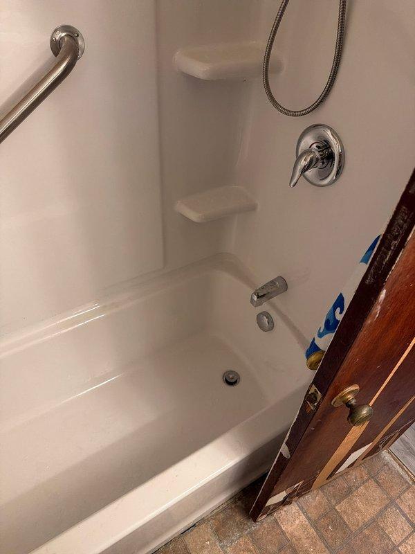 Completed full bathroom renovation involving the removal of existing bathtub and installation of a new Sterling Kohler 30x60 fiberglass bathtub and surround unit. Installed new waste and overflow assembly to ensure proper drainage function. Replaced existing shower valve with a new single-handle pressure-balanced shower control valve and chrome trim kit. Mounted chrome grab bar to surround wall for safety and accessibility compliance. Connected new chrome tub spout and verified all water supply lines for proper flow and temperature control. Installed flexible chrome shower hose assembly. All plumbing connections were tested for leaks and proper operation upon completion.