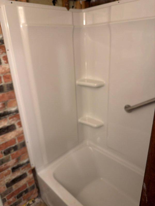 Completed full bathroom renovation involving the removal of existing bathtub and installation of a new Sterling Kohler 30x60 fiberglass bathtub and surround unit. Installed new waste and overflow assembly to ensure proper drainage function. Replaced existing shower valve with a new single-handle pressure-balanced shower control valve and chrome trim kit. Mounted chrome grab bar to surround wall for safety and accessibility compliance. Connected new chrome tub spout and verified all water supply lines for proper flow and temperature control. Installed flexible chrome shower hose assembly. All plumbing connections were tested for leaks and proper operation upon completion.