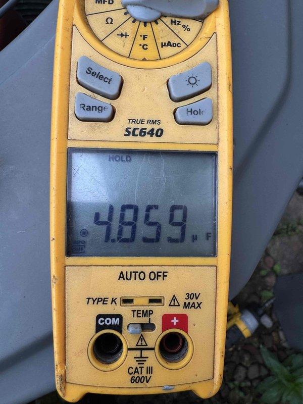 Performed routine air conditioning maintenance on a 12-year-old system. Conducted electrical diagnostics using clamp meter to verify amp draw of 0.58A and measured capacitor at 4859 microfarads to ensure proper compressor operation. All measurements within normal operating parameters; system operating efficiently with no deficiencies noted.