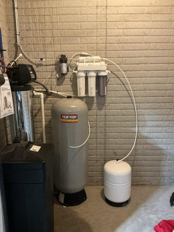 Responded to emergency call for salt tank leaking and flooding basement. Upon arrival, inspected AIO water treatment system including stainless steel filtration tank, brine tank with compromised seal, and associated plumbing connections. Identified leak source at brine tank valve assembly, performed necessary repairs to stop active flooding, and verified all system components including pressure tank, multi-stage filtration housings, and expansion tank were functioning properly with no additional leaks present.