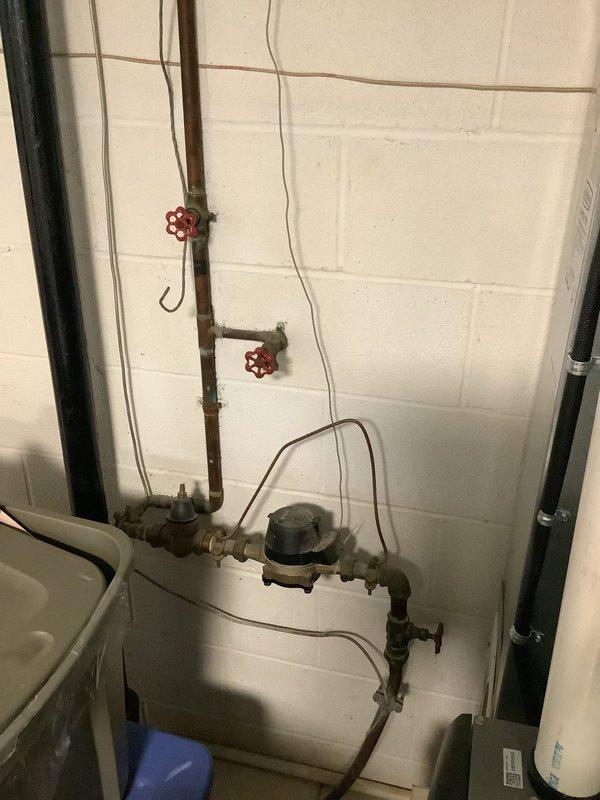 Responded to customer complaint of continued noise from tanked water heater following recent flush service. Upon inspection, observed AO Smith water heater installation with copper supply piping, expansion tank, and proper venting system in place. Examined all plumbing connections, valves, and water meter assembly for potential sources of noise generation. Assessed condition of aging copper piping showing surface corrosion and patina buildup. Documented water heater configuration including electrical panel proximity and exhaust vent routing. Investigation focused on identifying cause of persistent operational noise that began after previous maintenance visit.