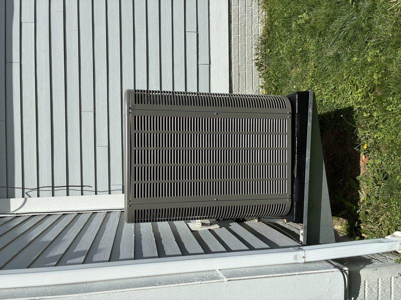 Responded to service call regarding outdoor condensing unit not sitting level following recent HVAC installation. Upon arrival, performed visual inspection of unit placement and verified installation on pad. Unit was found to be properly positioned and level on mounting platform. Documented equipment condition and placement with photos showing unit secured on decking with appropriate clearances maintained from structure and adequate ventilation access. No adjustments required as unit met manufacturer specifications for level installation.