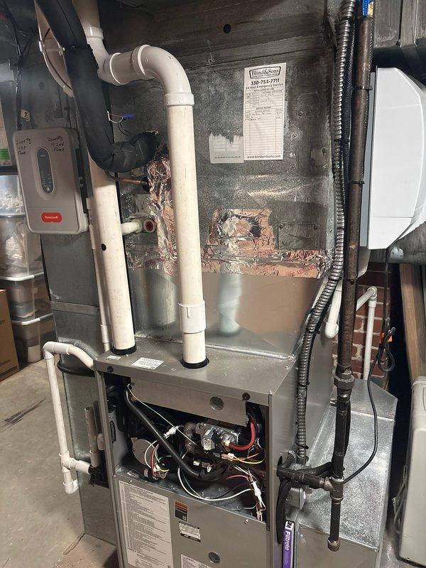 # HVAC Install - A/C & Coil

Completed installation of new air conditioning system with evaporator coil on existing gas furnace in basement utility area. Installed new A-coil unit atop furnace cabinet, establishing proper refrigerant line connections and condensate drainage. Integrated new cooling components with existing ductwork system, utilizing metallic flex connector for proper airflow distribution. Verified all electrical connections to furnace control board and installed Honeywell thermostat control on adjacent wall for system operation. Routed and secured refrigerant linesets with appropriate insulation and support. Tested system startup, confirmed proper airflow through supply plenum, and verified condensate drainage through existing PVC piping. All components operational and system cooling effectively upon completion.