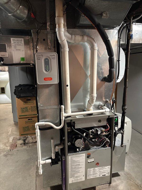 # HVAC Install - A/C & Coil

Completed installation of new air conditioning system with evaporator coil on existing gas furnace in basement utility area. Installed new A-coil unit atop furnace cabinet, establishing proper refrigerant line connections and condensate drainage. Integrated new cooling components with existing ductwork system, utilizing metallic flex connector for proper airflow distribution. Verified all electrical connections to furnace control board and installed Honeywell thermostat control on adjacent wall for system operation. Routed and secured refrigerant linesets with appropriate insulation and support. Tested system startup, confirmed proper airflow through supply plenum, and verified condensate drainage through existing PVC piping. All components operational and system cooling effectively upon completion.