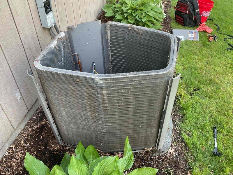 Completed preventive maintenance cooling visit on 10-year-old residential air conditioning system. Performed comprehensive inspection of outdoor condenser unit, noting significant rust and corrosion on base pan and internal components with debris accumulation requiring attention. Documented equipment condition with photographs showing compressor, condenser coils, refrigerant lines, and electrical connections for maintenance records.