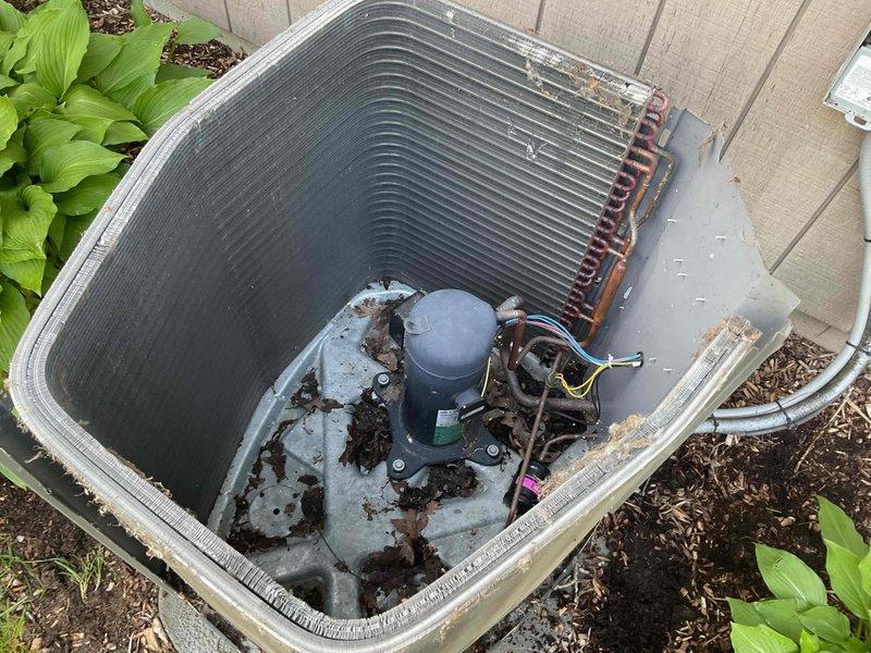 Completed preventive maintenance cooling visit on 10-year-old residential air conditioning system. Performed comprehensive inspection of outdoor condenser unit, noting significant rust and corrosion on base pan and internal components with debris accumulation requiring attention. Documented equipment condition with photographs showing compressor, condenser coils, refrigerant lines, and electrical connections for maintenance records.