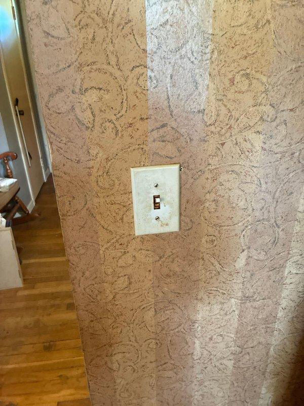 Completed installation of flush-mount light fixture in kitchen featuring decorative textured glass panel with rippled pattern and dark bronze circular frame. Verified proper electrical connections, tested switch operation, and ensured secure mounting to ceiling with all components functioning correctly.
