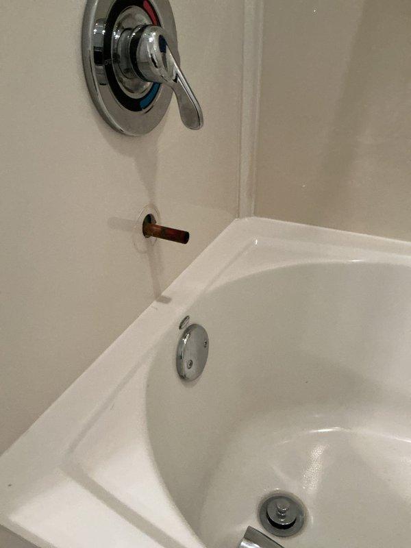 Responded to service call for bathtub diverter malfunction where the tub spout diverter lever was stuck in the down position and unable to engage to redirect water flow to the shower head. Inspected the chrome tub spout assembly and diverter mechanism, confirmed the diverter was frozen due to mineral buildup and corrosion preventing proper operation. Successfully freed and restored functionality to the diverter system, allowing proper water diversion between tub spout and shower head.