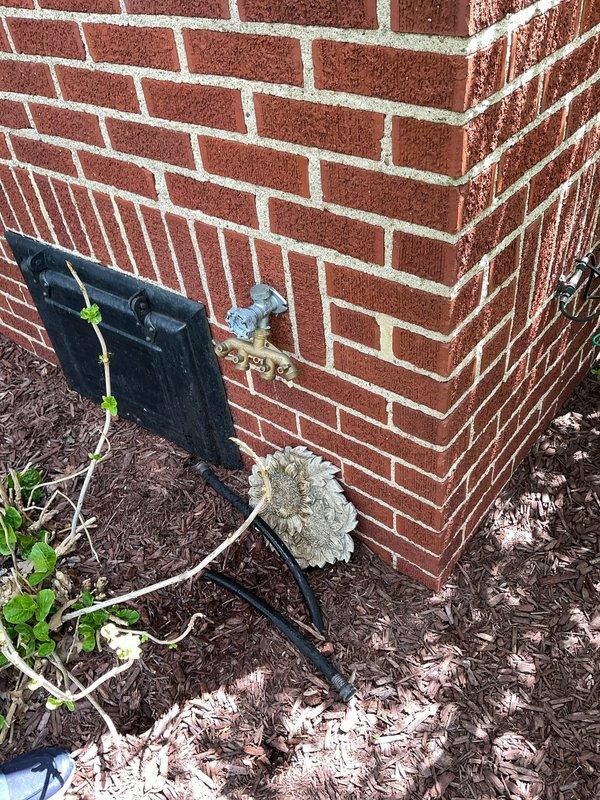 Completed installation of customer-supplied kitchen faucet with high-arched spout and separate spray nozzle in double-basin stainless steel sink. Repaired leaking outdoor hose bib at exterior brick wall foundation, restoring proper function and eliminating water waste.