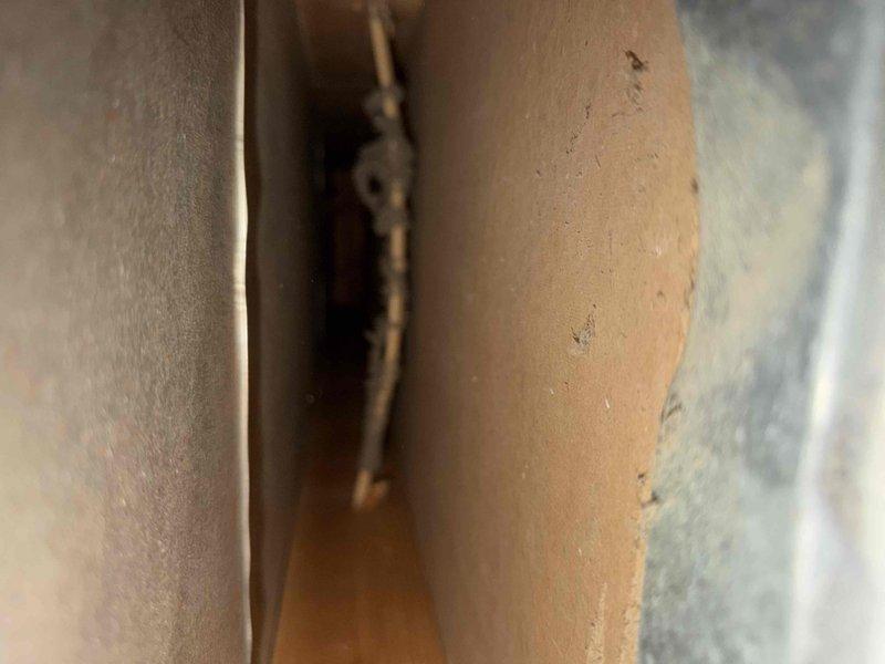 Completed comprehensive duct cleaning service for system with up to 14 vents, including mold and aroma treatment. Accessed ductwork through various entry points, removed accumulated dust, debris, and contaminants from supply and return air pathways, and applied antimicrobial treatment to address mold concerns and eliminate odors. Documentation photos captured insulation components and trim areas near vent locations to verify thorough access and cleaning completion.