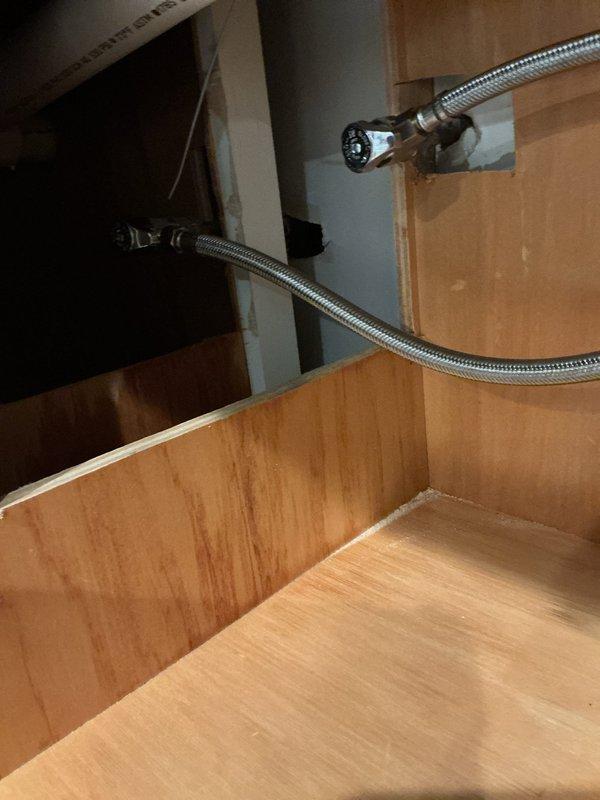 Removed existing toilet from bathroom to facilitate vanity work. Installed customer-supplied undermount stainless steel sink into existing dark gray countertop with professional sealing and mounting. Installed customer-supplied pull-down kitchen-style faucet with brushed nickel finish using single-hole mounting configuration. Connected flexible braided stainless steel supply lines to hot and cold water supplies using truck stock fittings. Installed matching soap dispenser accessory fixture adjacent to main faucet. Reset toilet to original position after vanity installation was completed, ensuring proper seal and function. Tested all plumbing connections for leaks and verified proper water flow and drainage. All installations completed using existing cabinet structure with no modifications required to white cabinetry framework.